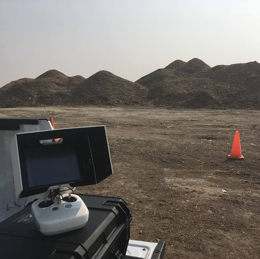 Photo of controller with gravel piles in background to measure